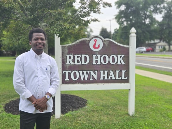 Stephen Akindipe MS ‘25 in front of the Red Hook Town Hall sign.