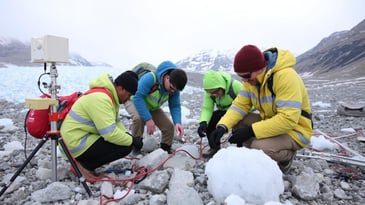 scientists in a snowy environment studying melting glaciers