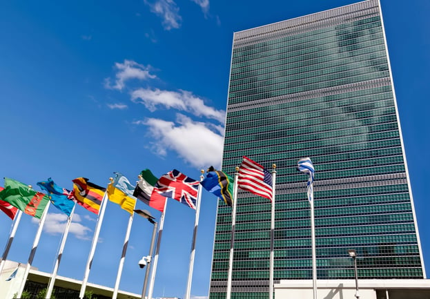 Multiple flags fly in front of the UN Headquarters