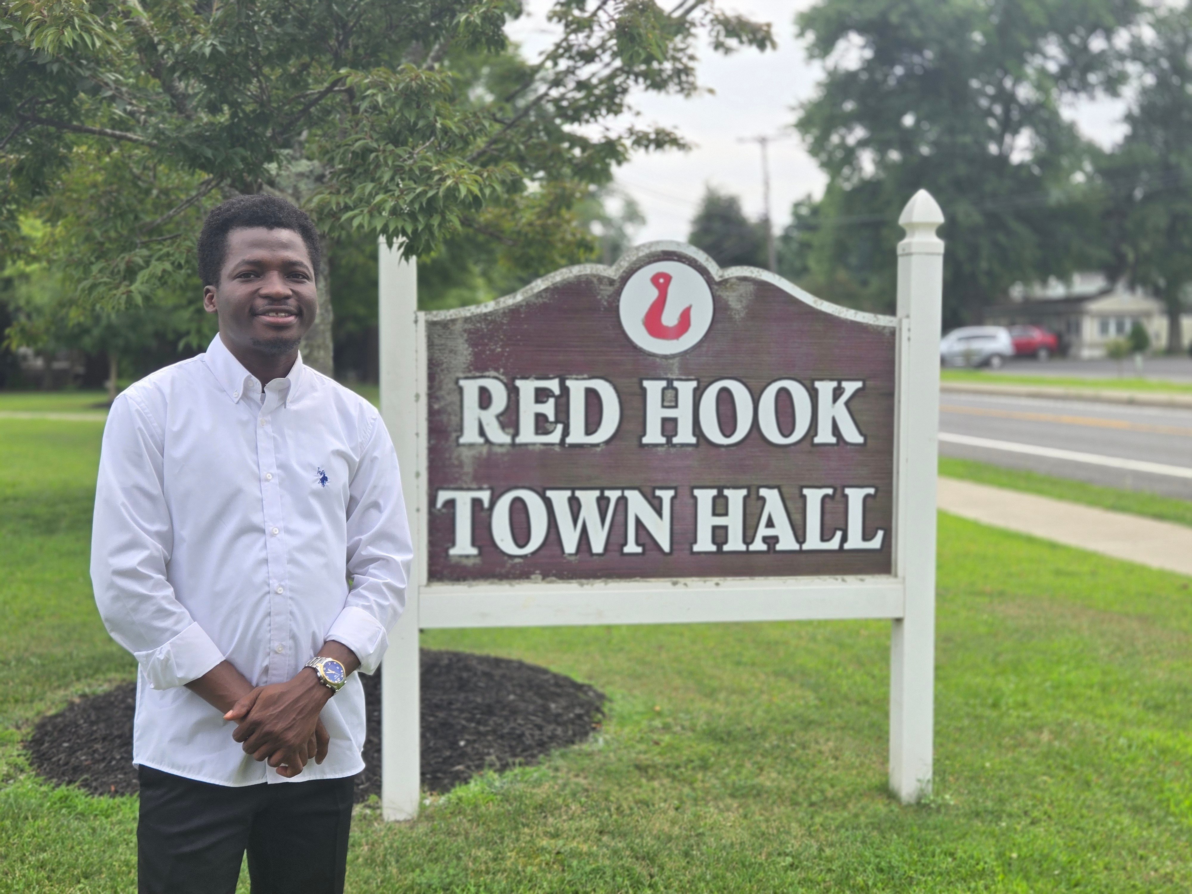 Stephen Akindipe MS ‘25 in front of the Red Hook Town Hall sign.